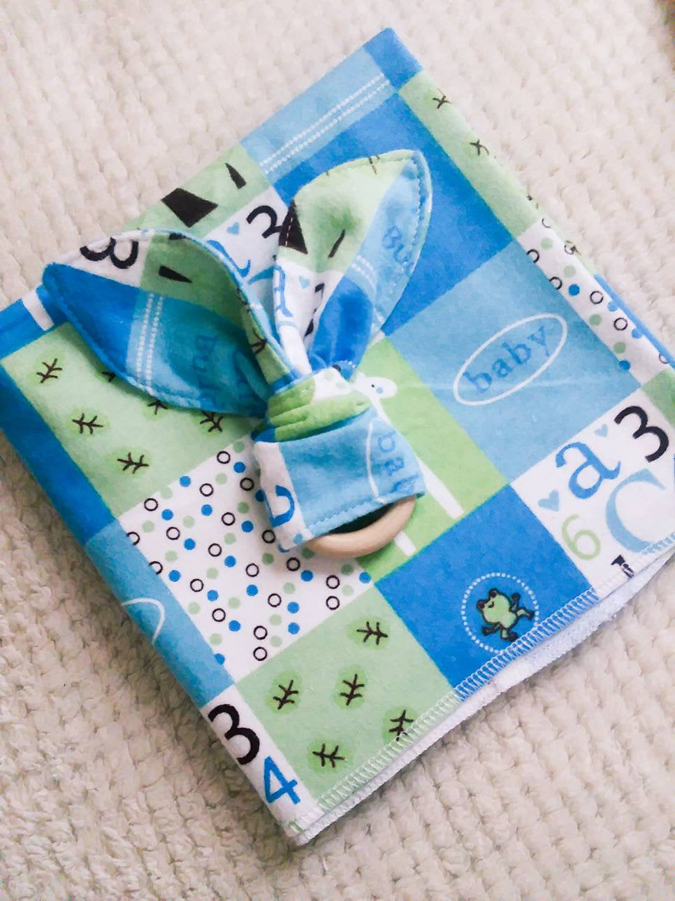 Baby bunny ear teether and receiving blanket set.